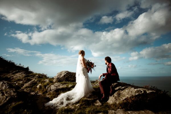 Bride and groom on dramatic clifftop rocks overlooking the sea, Valley of Rocks Lynmouth elopement wedding photography