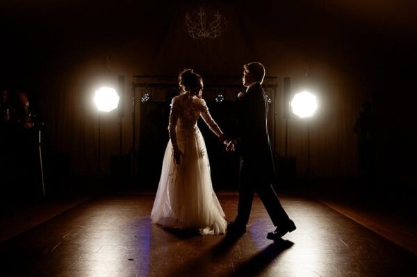 Bride and groom sharing their first dance in dramatic spotlight at a Cornwall wedding reception at Tredudwell