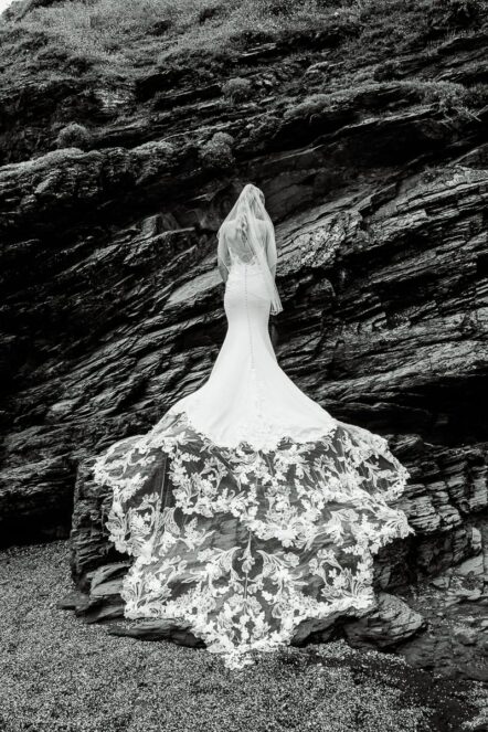 Bride in lace mermaid wedding dress on the rocks at Church Cove, Gunwalloe, near Helston, Cornwall