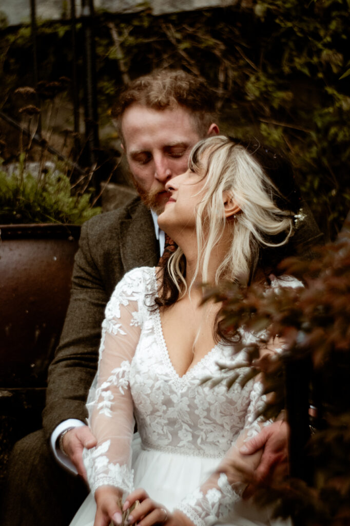 Bride and groom kissing on stone steps at Wonwood Barton Tavistock Devon wedding