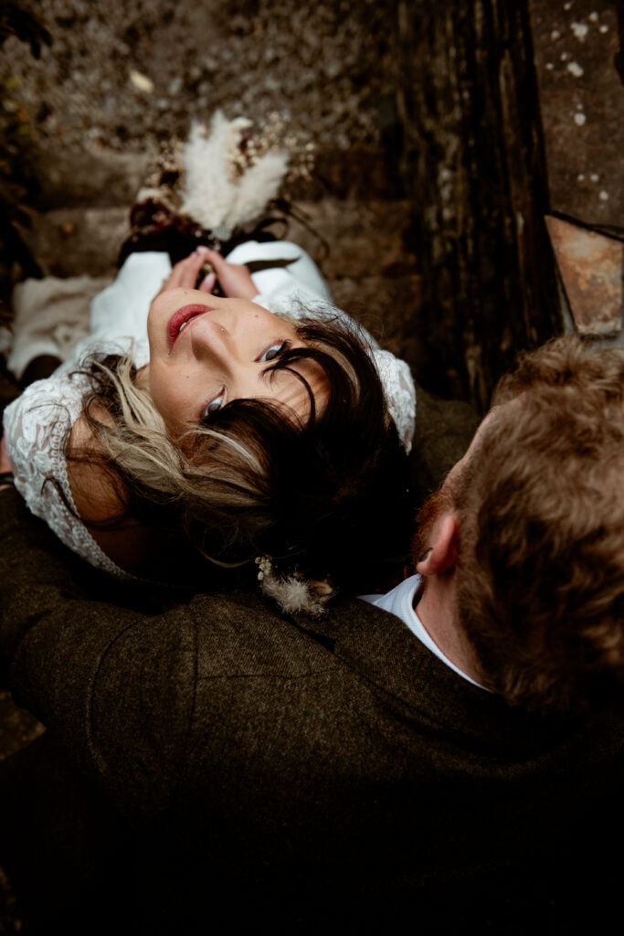 Bride lying back on groom tweed suit overhead portrait at Wonwood Barton Tavistock wedding