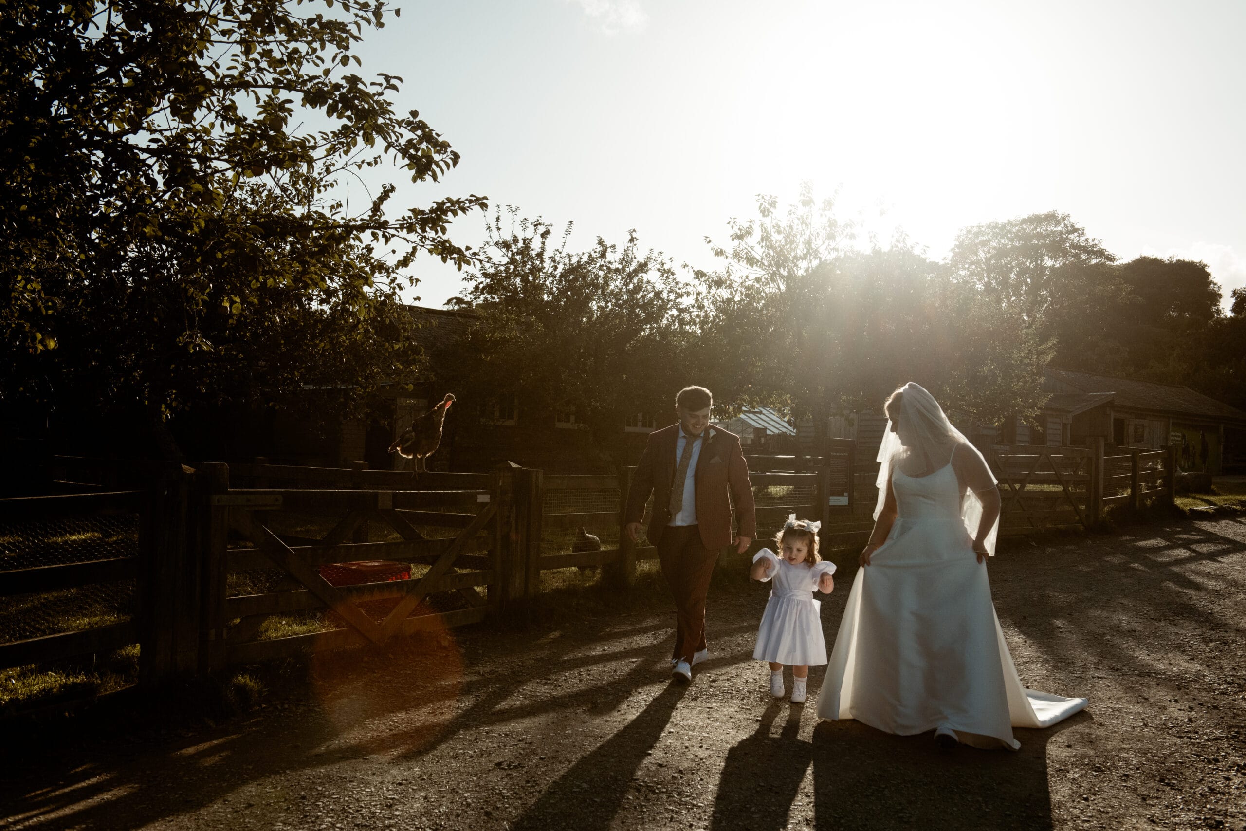 Bride and daughter walking together in golden evening light at Lost Gardens of Heligan Cornwall